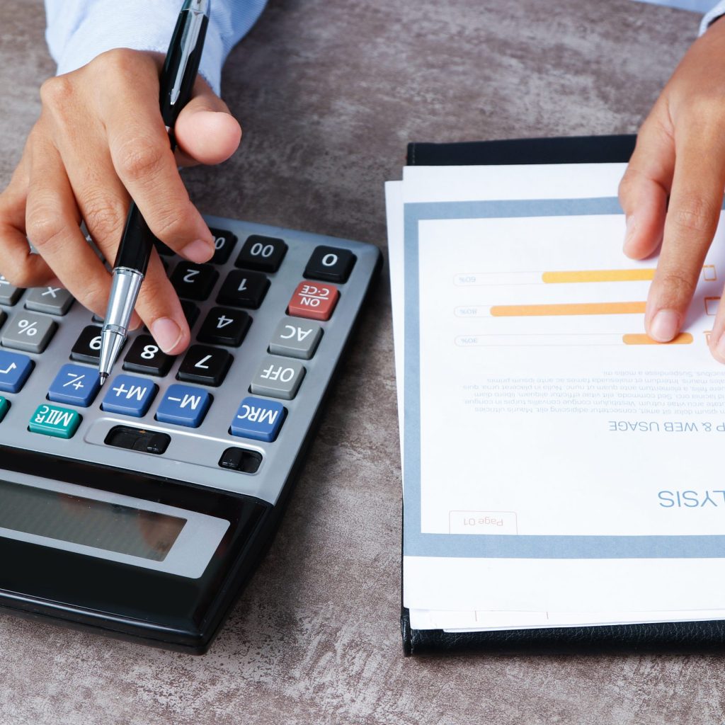 Closeup of analyst using calculator. Person working with diagram at desk. Marketing concept. Cropped view.