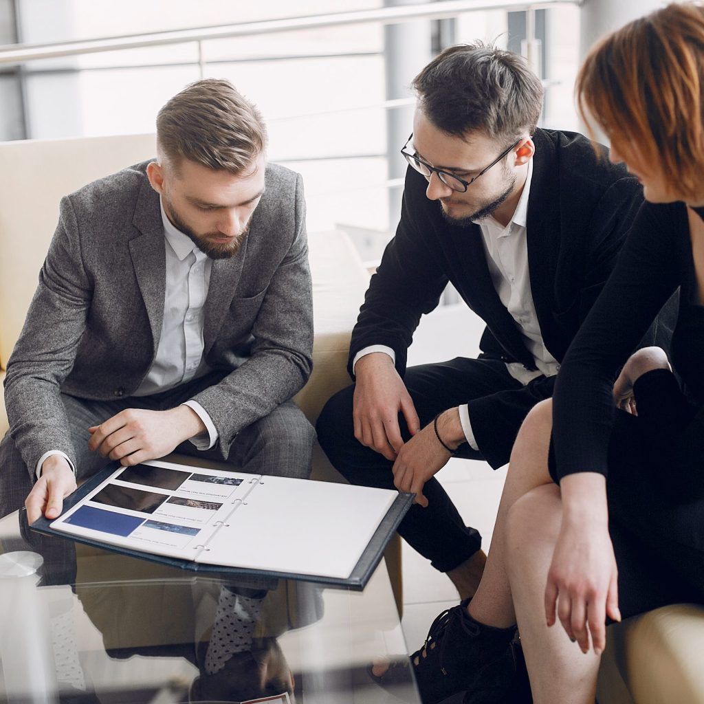 Couple in a car salon. Family buying the car. Elegant woman with her husband. Assistant with a clients